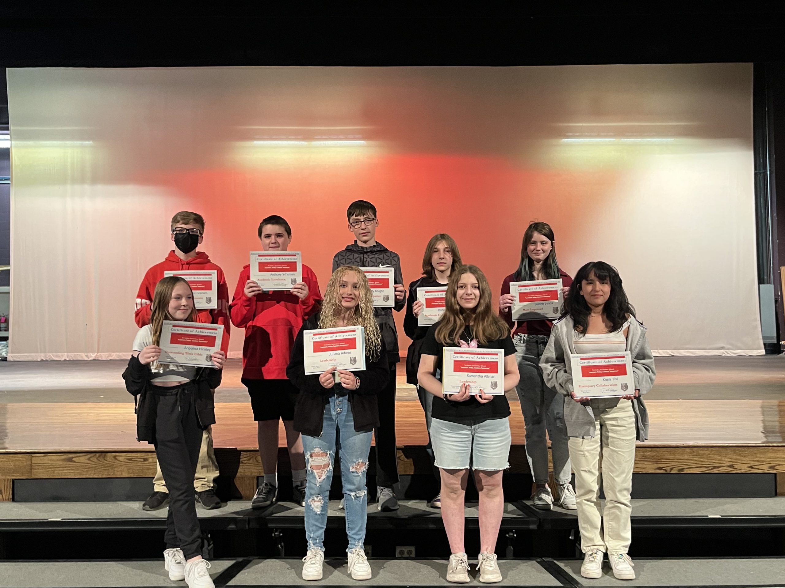 Two rows of students lined up holding certificates